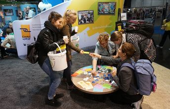 Rebecca Görmann, Mitarbeiterin für Öffentlichkeitsarbeit, zusammen mit Jugendlichen an der ConAct-Ecke. 