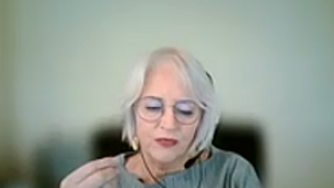 Frau mit Brille gestikuliert und spricht