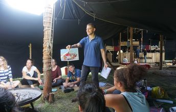 Avner Inbar, israelischer Freiwilliger bei ConAct, hält während seinem Workshop „Vom Garten Eden nach Jerusalem: Eine Reise auf den Spuren des Judentums“ ein Foto hoch.
