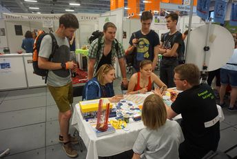 Jugendliche sitzen an einem Tisch und versuchen ihren Namen auf hebräisch zu schreiben.