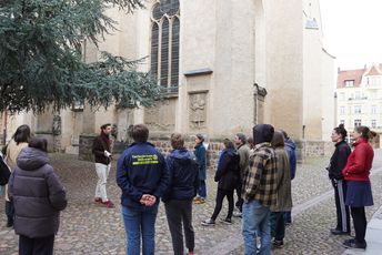 Eine Gruppe steht vor der Stadtkirche in Wittenberg.