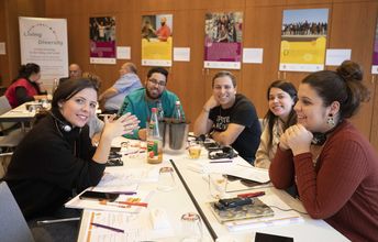 Eine Gruppe junger Menschen sitzt zusammen an einem Tisch