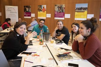 Eine Gruppe junger Menschen sitzt zusammen an einem Tisch