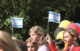 Mädchen mit zwei Israelfahnen im Hintergrund