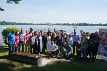 die Fachkräfte stehen vor einem See für ein Gruppenfoto.