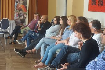 Teilnehmende sitzen auf Stühlen und hören einem Vortrag zu.