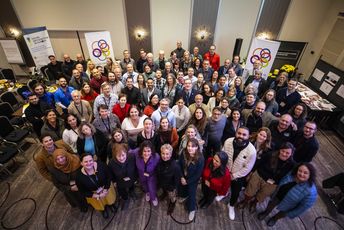 Eine große Gruppe von Menschen lächelt in die Kamera.