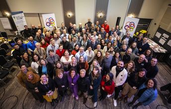 Eine große Gruppe von Menschen lächelt in die Kamera.