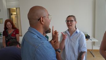 Ein Mann und ein Frau stehen sich im angeregten Dialog gegenüber.