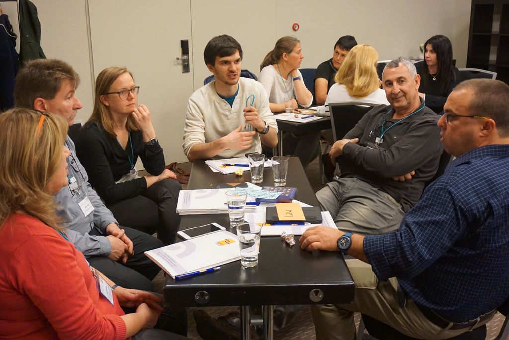 Eine Gruppe sitzt am Tisch und unterhält sich angeregt