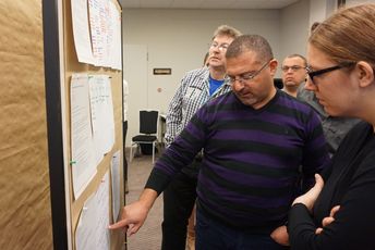 Zwei Teilnehmende stehen vor einer Pinnwand.