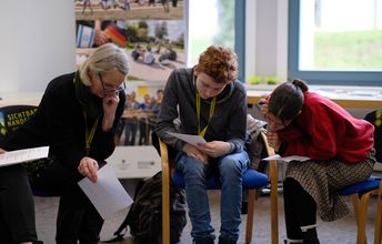 Eine Kleingruppe bearbeitet konzentriert eine Aufgabe.