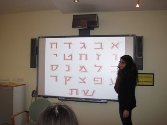 Or Goren erklärt Teilnehmern und Teilnehmerinnen die hebräische Schrift.