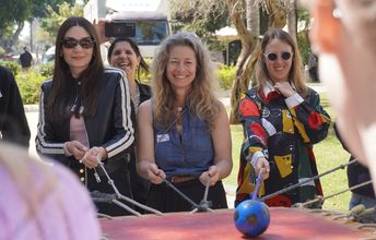 Drei Personen in Freien bei einer spielerischen Aktivität