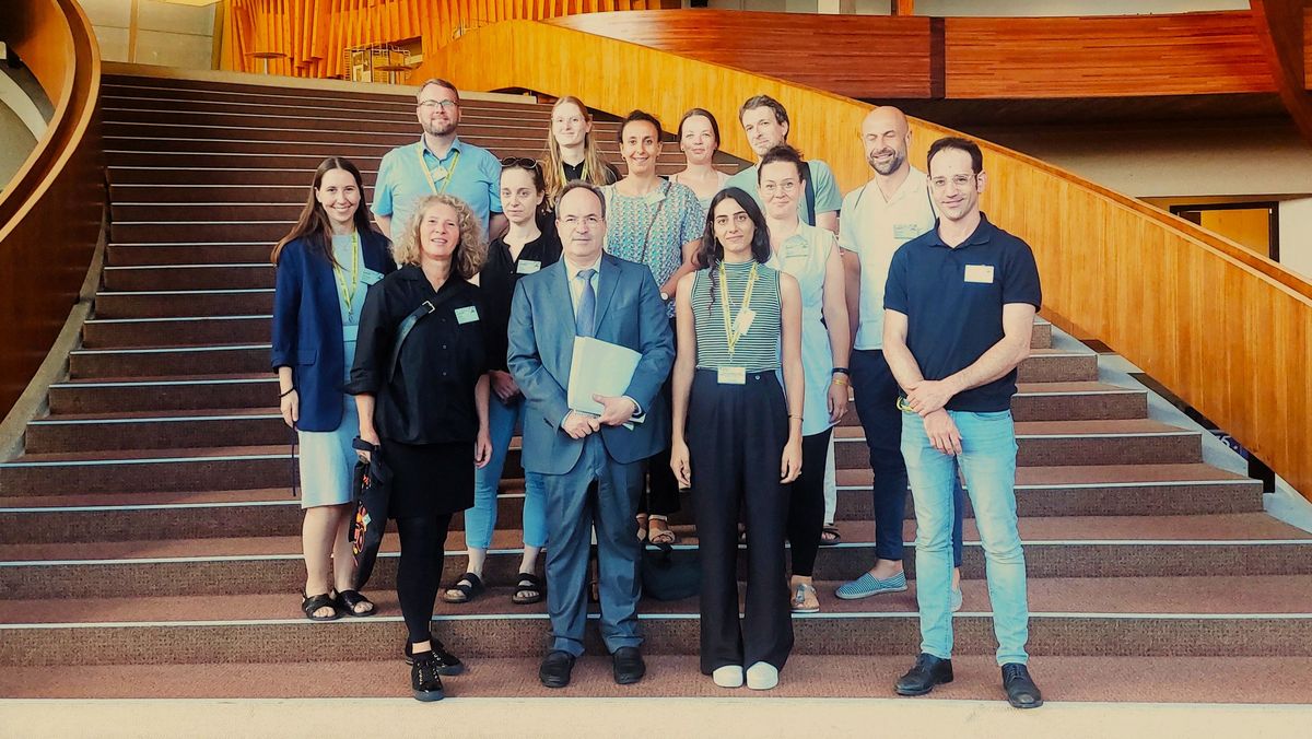Foto einer repräsentativen Gruppe, die auf einer geschwungenen Treppe steht.