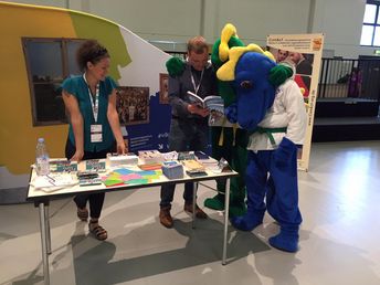 Jonas Hahn, pädagogischer Mitarbeiter beo ConAct, erklärt den Maskottchen des Ju-Jutso-Verbandes eine Broschüre.