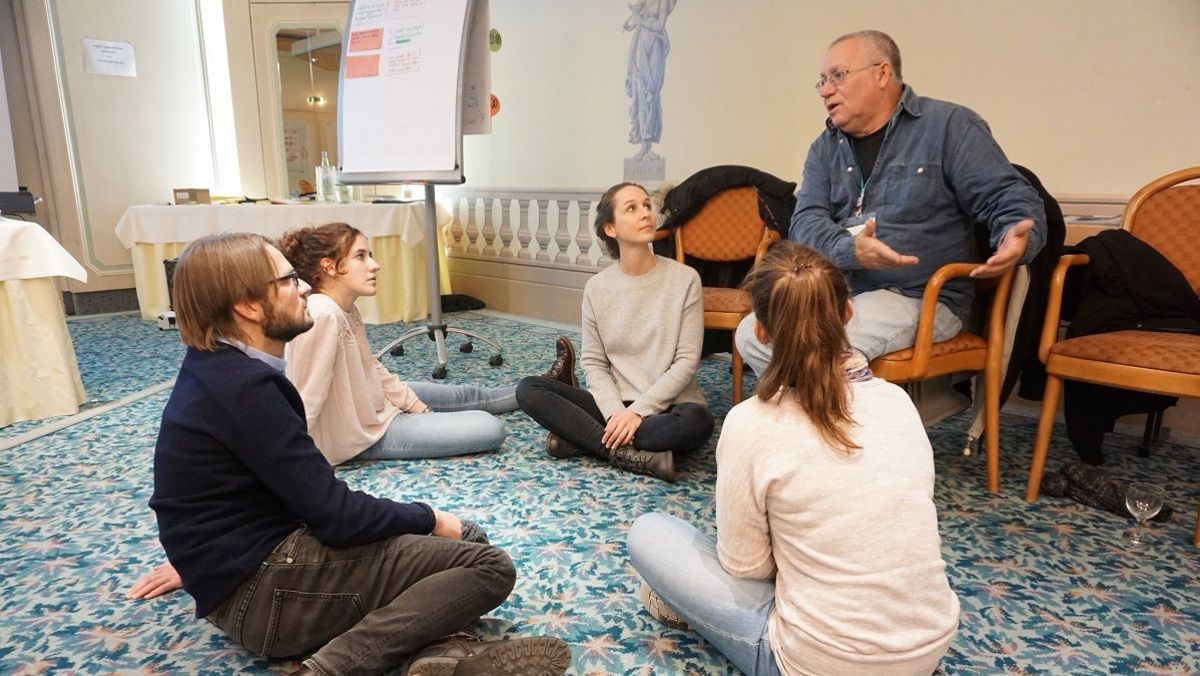 Vier junge Menschen und ein älterer Herr miteinander im Gespräch