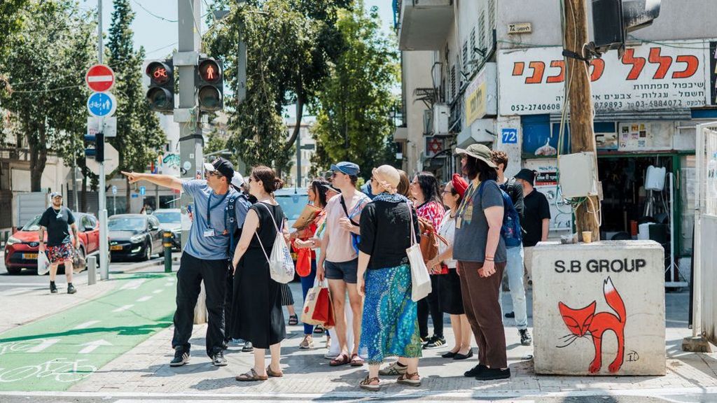 Menschengruppe steht an einer Kreuzung während einer Stadtführung.
