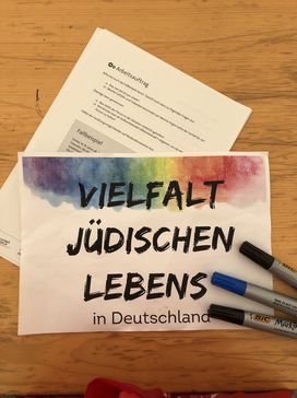 Blattpapier mit Wokrshoptitel "Vielfalt jüdischen Lebens in Deutschland" mit drei Filzstiften an der Seite.