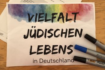 Blattpapier mit Wokrshoptitel "Vielfalt jüdischen Lebens in Deutschland" mit drei Filzstiften an der Seite.