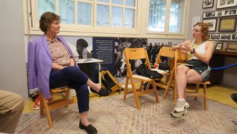 Zwei Personen sitzen einander zugewandt auf Stühlen und unterhalten sich.