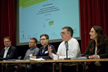 Die Verantwortlichen der Fach- und Fördereinrichtungen sitzen nebeneinander auf einem Podium stellen sich vor.