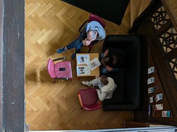 Aus Vogelperspektive Blick auf Kleingruppe im konzentrierten Gespräch.