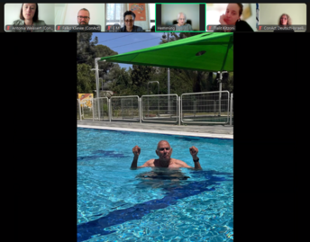 Älterer Herr im Pool streckt geballte Fäuste in die Luft