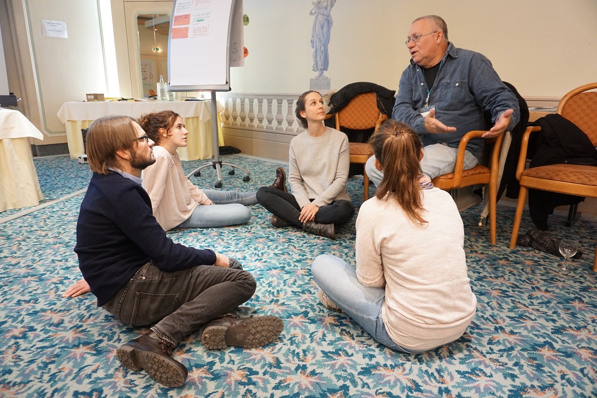 Auswertung/Evaluation Vier junge Menschen und ein älterer Herr miteinander im Gespräch